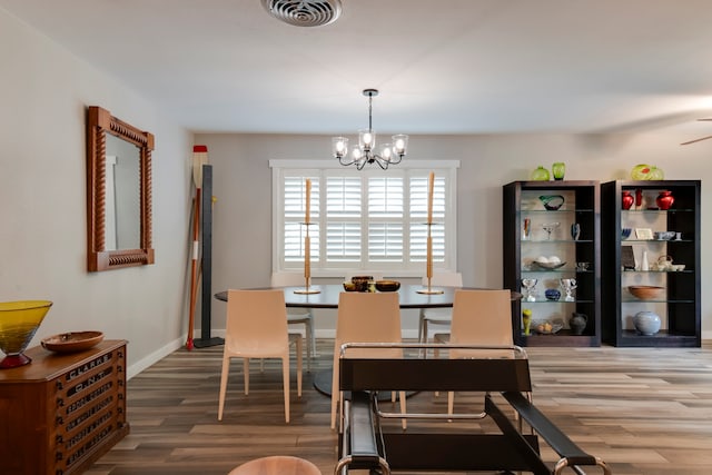 dining room featuring wood-type flooring and a chandelier