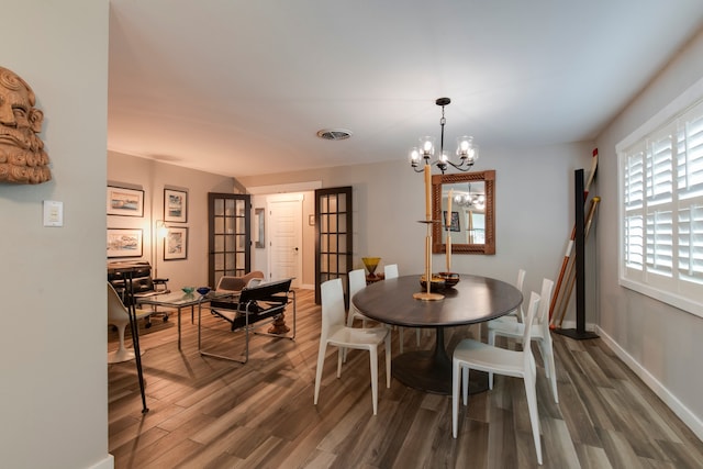 dining room featuring dark wood-type flooring and a chandelier