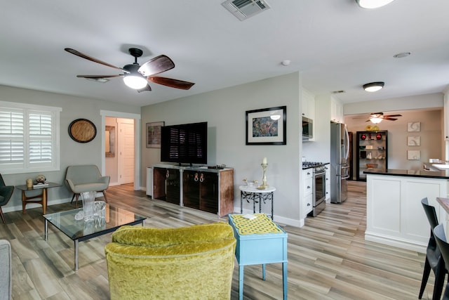 living room featuring light hardwood / wood-style flooring and ceiling fan