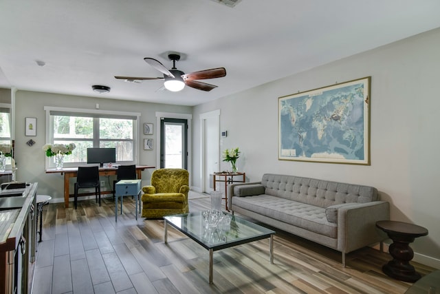 living room with dark hardwood / wood-style flooring and ceiling fan