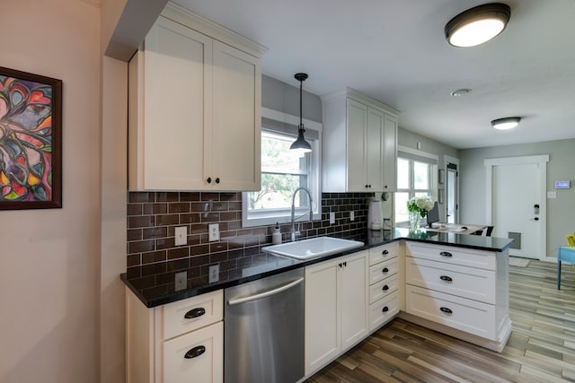 kitchen featuring dishwasher, tasteful backsplash, hanging light fixtures, sink, and hardwood / wood-style flooring