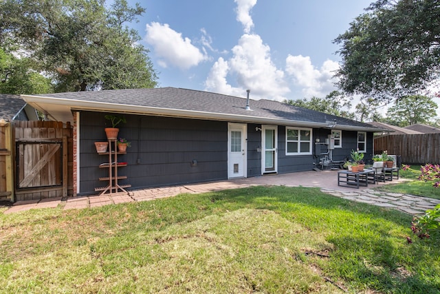 rear view of property featuring a lawn and a patio area