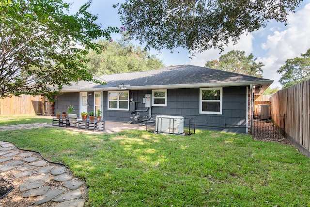 rear view of property with a yard, central AC, and a patio