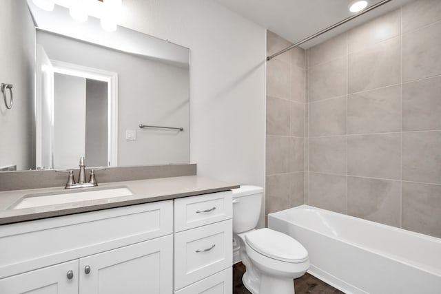 full bathroom with tiled shower / bath combo, vanity, and toilet