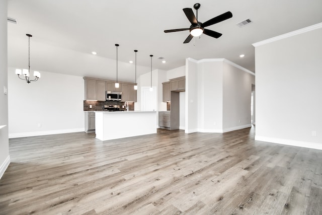 unfurnished living room featuring crown molding, light hardwood / wood-style flooring, and ceiling fan with notable chandelier