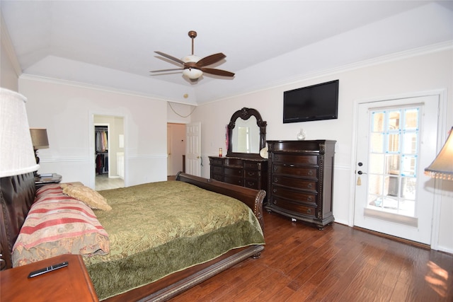 bedroom with a walk in closet, dark hardwood / wood-style flooring, ornamental molding, access to outside, and ceiling fan