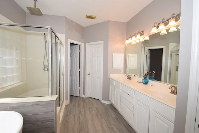 bathroom featuring hardwood / wood-style floors, vanity, and shower with separate bathtub