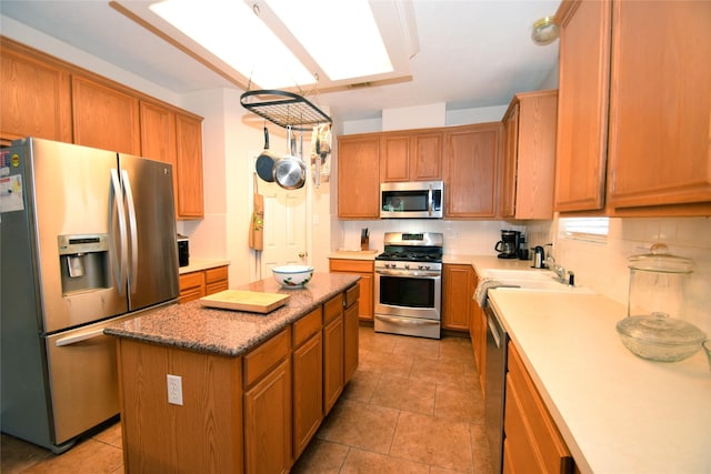 kitchen with a center island, light tile patterned floors, stainless steel appliances, and tasteful backsplash