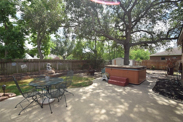 view of patio featuring a hot tub and a storage shed