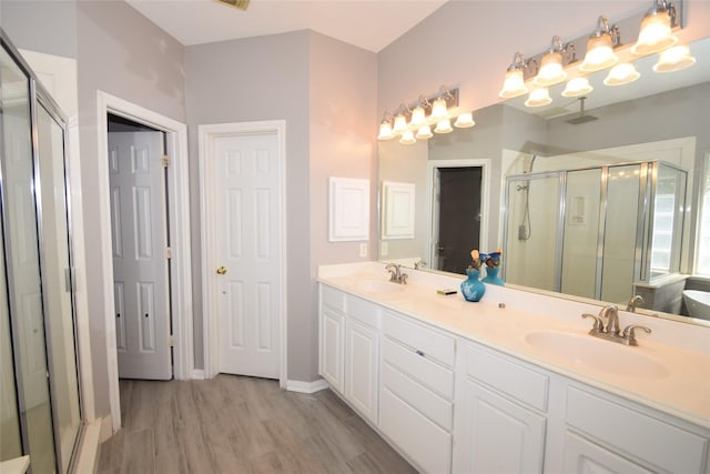 bathroom featuring hardwood / wood-style floors, vanity, and an enclosed shower