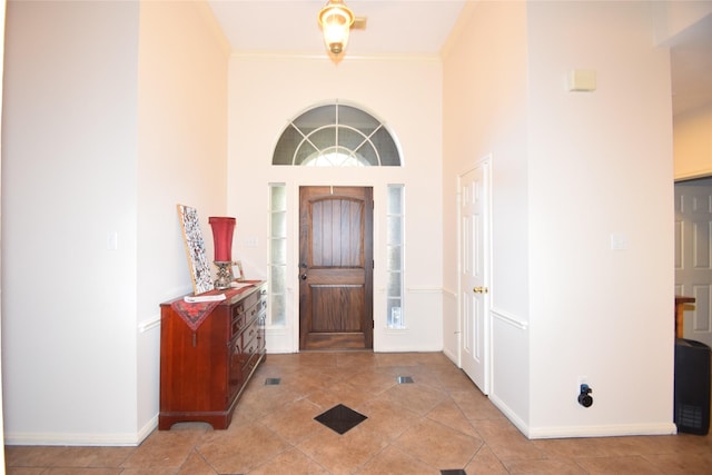 entryway featuring light tile patterned flooring and a high ceiling