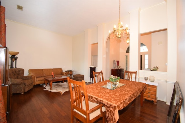 dining room with ornamental molding, dark wood-type flooring, and an inviting chandelier