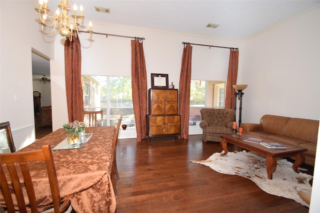 interior space featuring ornamental molding, ceiling fan with notable chandelier, a wealth of natural light, and dark wood-type flooring