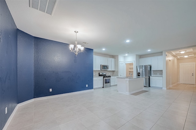 kitchen with appliances with stainless steel finishes, a center island, white cabinetry, and hanging light fixtures