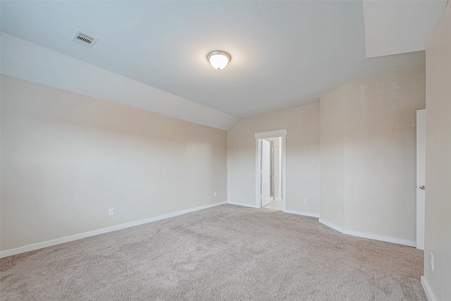 carpeted spare room with lofted ceiling