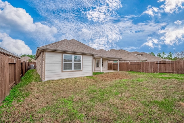 back of house featuring a patio area and a lawn