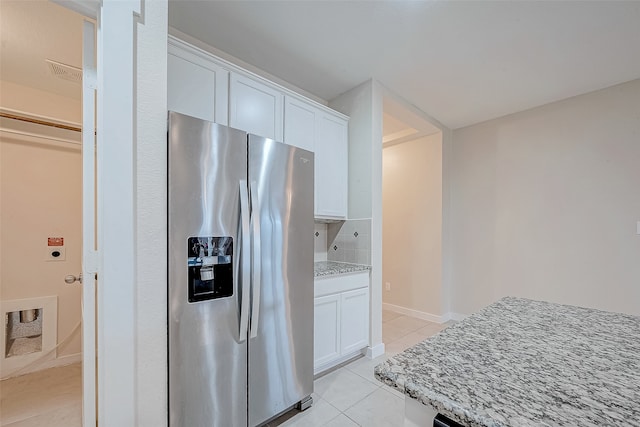 kitchen with light stone countertops, white cabinets, and stainless steel refrigerator with ice dispenser