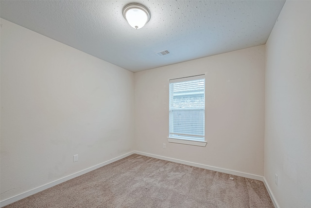 carpeted empty room with a textured ceiling