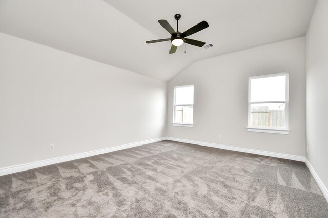 unfurnished room featuring lofted ceiling, plenty of natural light, ceiling fan, and carpet flooring