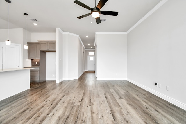 unfurnished living room featuring ceiling fan, ornamental molding, and wood-type flooring