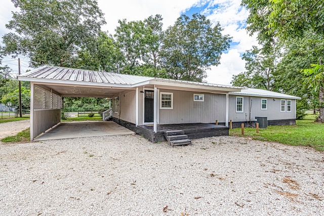 view of front of house with a front lawn, cooling unit, and a carport