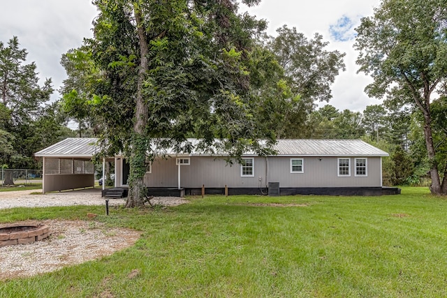 back of property with cooling unit, a yard, and a carport