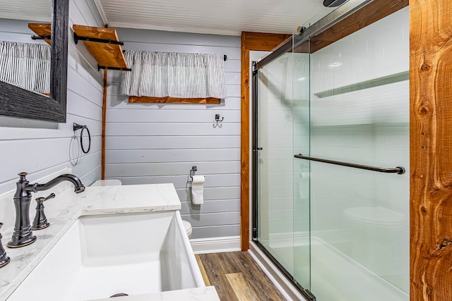 bathroom featuring vanity, toilet, wood-type flooring, and a shower with shower door