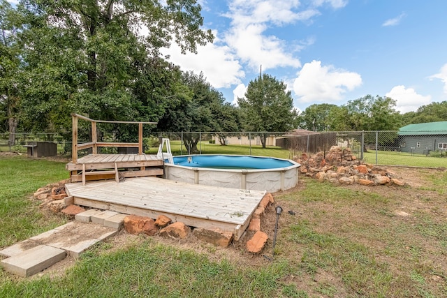 view of pool with a wooden deck and a lawn