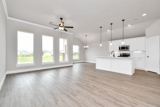 kitchen featuring open floor plan, stainless steel microwave, range, and a healthy amount of sunlight