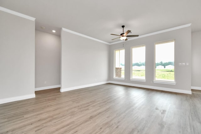 spare room with ceiling fan, ornamental molding, wood finished floors, and baseboards