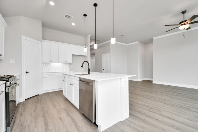 kitchen with appliances with stainless steel finishes, open floor plan, visible vents, and a sink