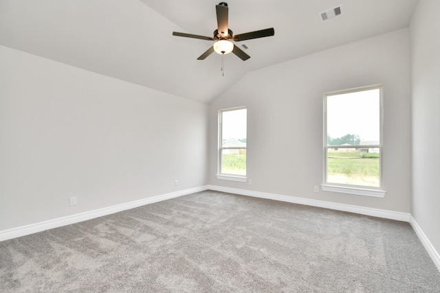 unfurnished room with lofted ceiling, a ceiling fan, visible vents, baseboards, and carpet