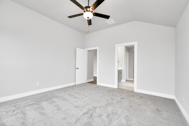 unfurnished bedroom with carpet floors, lofted ceiling, a ceiling fan, ensuite bath, and baseboards