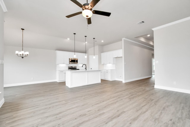 kitchen with open floor plan, appliances with stainless steel finishes, an island with sink, and visible vents