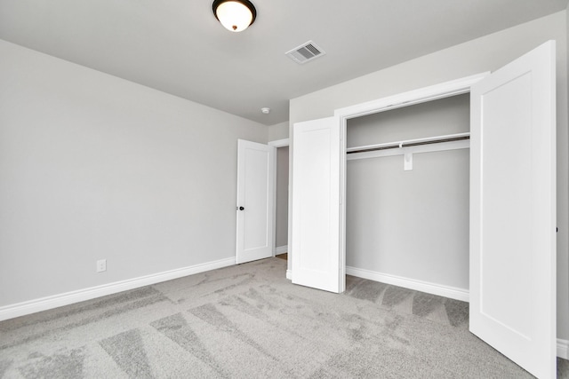 unfurnished bedroom with carpet floors, baseboards, visible vents, and a closet