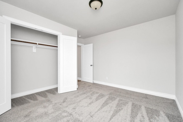 unfurnished bedroom featuring carpet, a closet, and baseboards