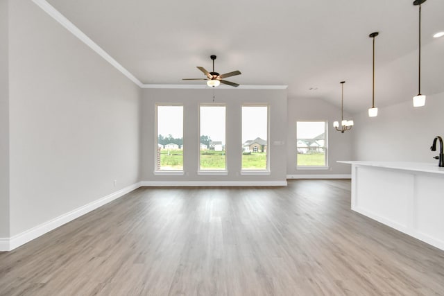 unfurnished living room with crown molding, lofted ceiling, wood finished floors, baseboards, and ceiling fan with notable chandelier