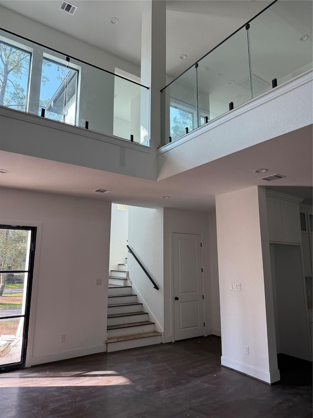 staircase with a high ceiling and hardwood / wood-style flooring