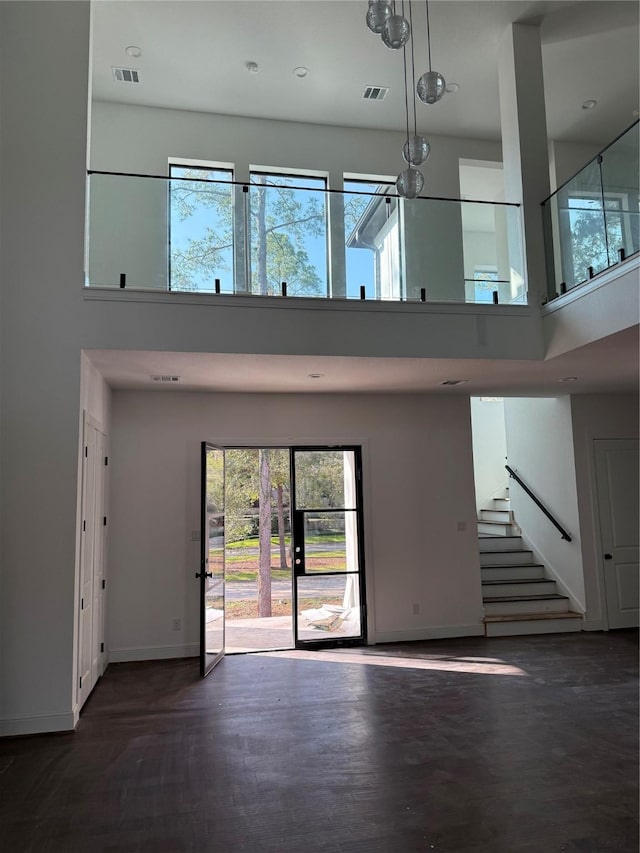 unfurnished living room with a towering ceiling