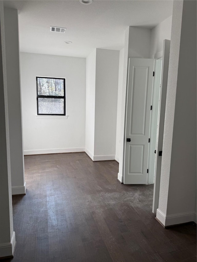 unfurnished room with dark wood-type flooring