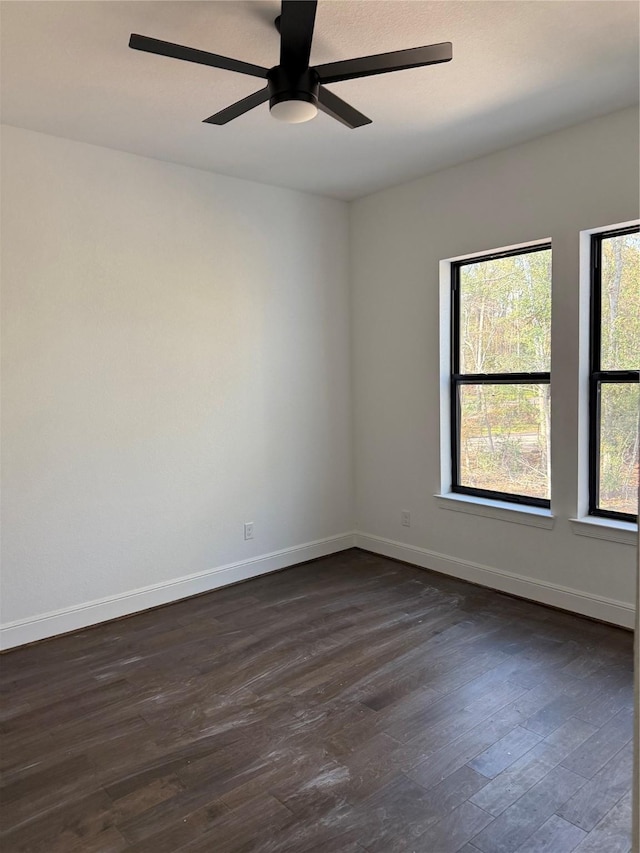 empty room with ceiling fan and dark wood-type flooring