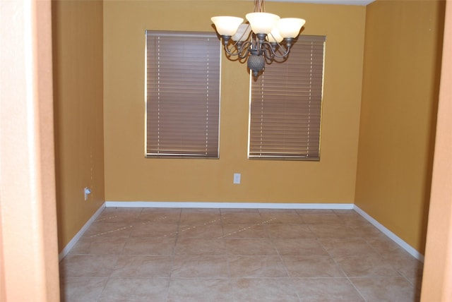 unfurnished room with light tile patterned flooring and an inviting chandelier