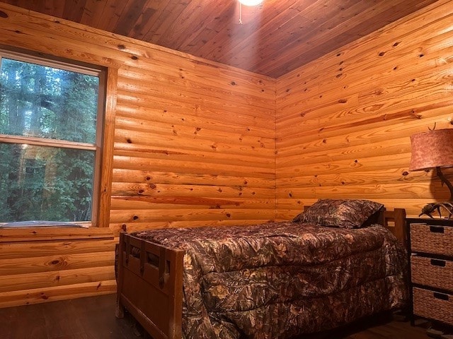 bedroom with wood ceiling, rustic walls, and wood-type flooring