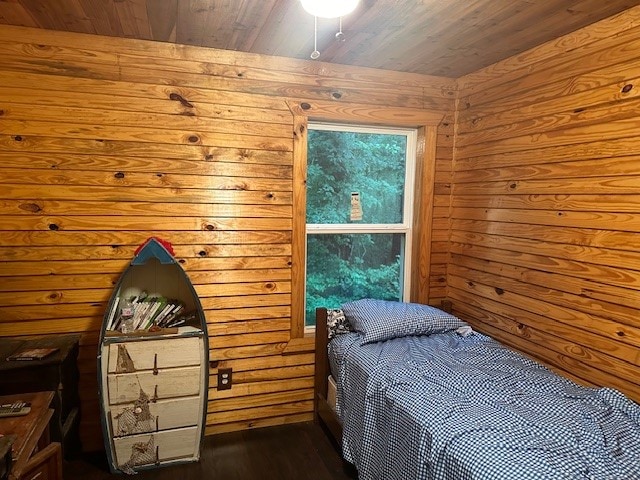 bedroom featuring wooden ceiling, dark wood-type flooring, and wood walls