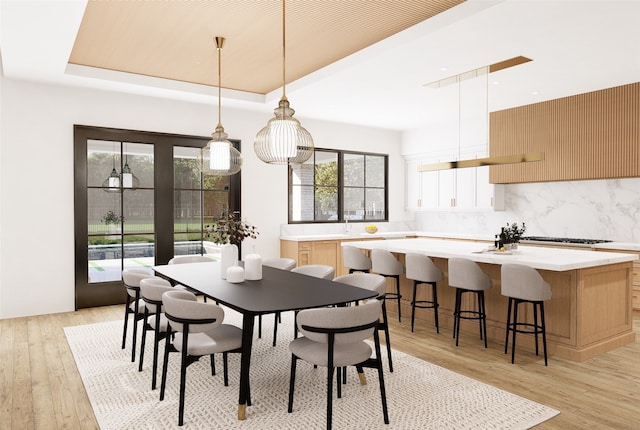 dining area featuring a tray ceiling and light hardwood / wood-style floors