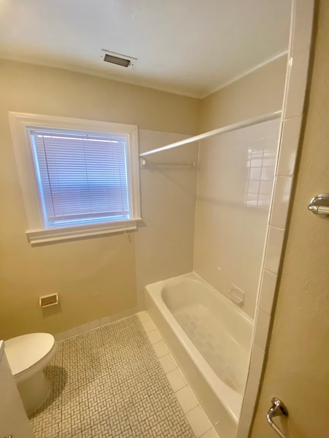 bathroom with tub / shower combination, toilet, and tile patterned flooring