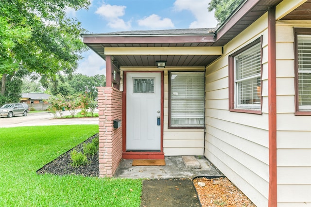 property entrance with a lawn