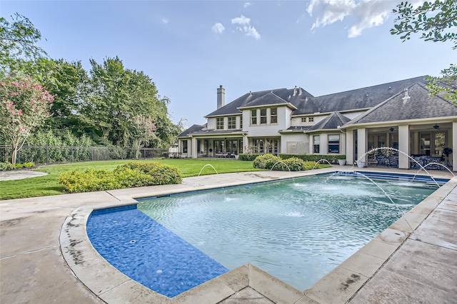 view of swimming pool featuring a yard, pool water feature, and a patio area