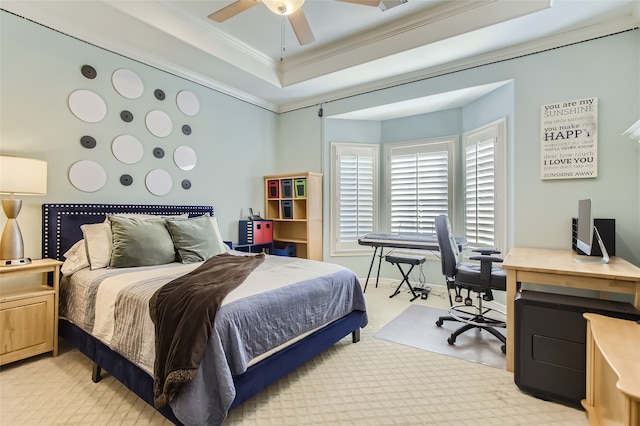 carpeted bedroom with ceiling fan, a raised ceiling, and ornamental molding