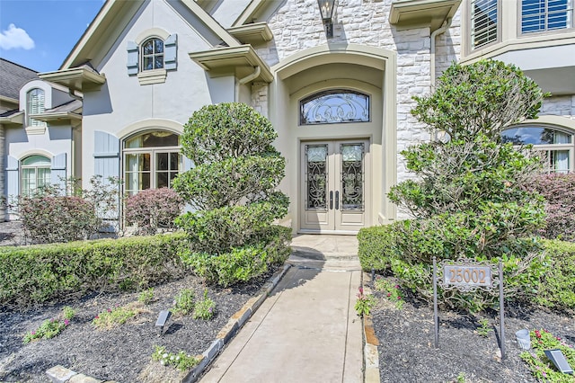 25002 Falling Water Estates Ln, Katy, TX 77494 - doorway to property featuring french doors, stone siding, and stucco siding